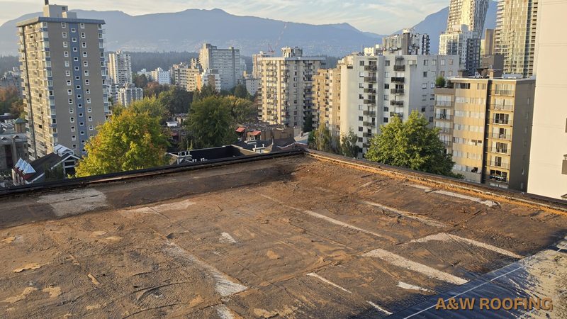 Stripped flat roof deck ready for new membrane, North Shore mountains behind, Vancouver, A&W Roofing Ltd
